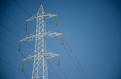 Strommast gegen blauen Himmel